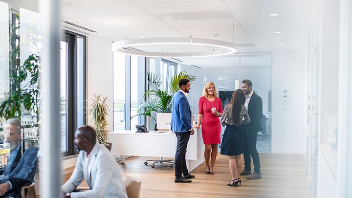 Dirigeants d'entreprise appréciant la conversation avec divers collègues au bureau