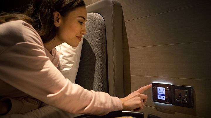 Woman using hotel room control panel