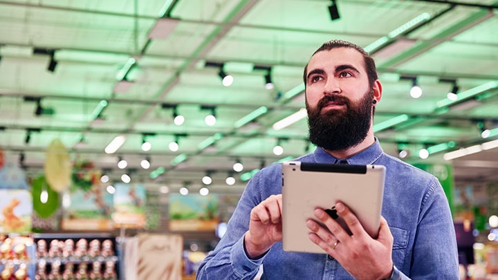 Un homme contrôlant l'environnement de son magasin via une tablette