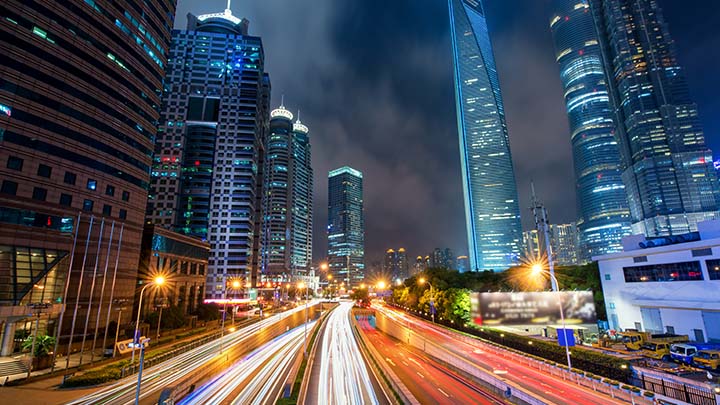 Weg met veel verkeer met skyline van de stad in de avond