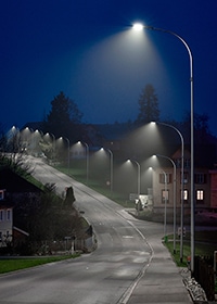 Eine mit Straßenlampen beleuchtete Straße bei Nacht
