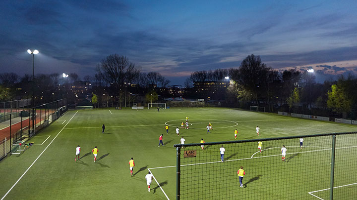 Campo de fútbol local con un partido en juego