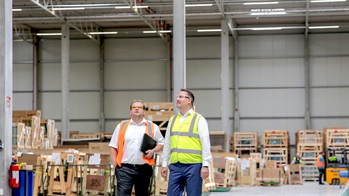 Two warehouse supervisors looking around