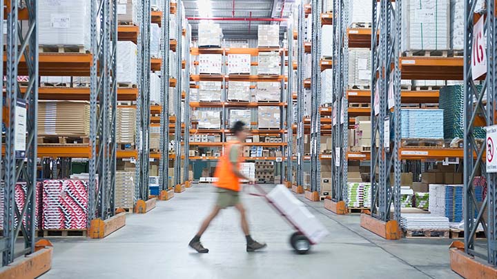 Worker in warehouse using trolley