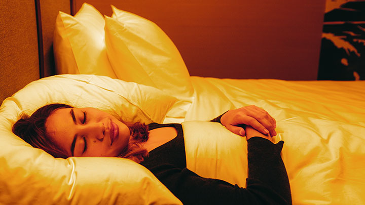 Femme dormant avec un éclairage circadien dans une chambre d'hôtel