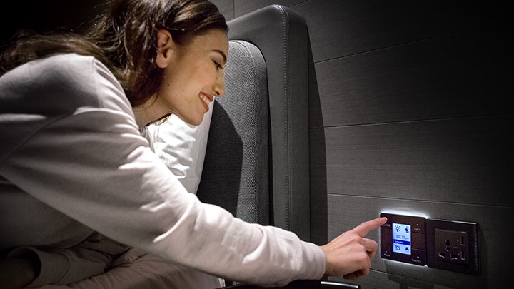 Woman using personal controls in hotel room to control lighting