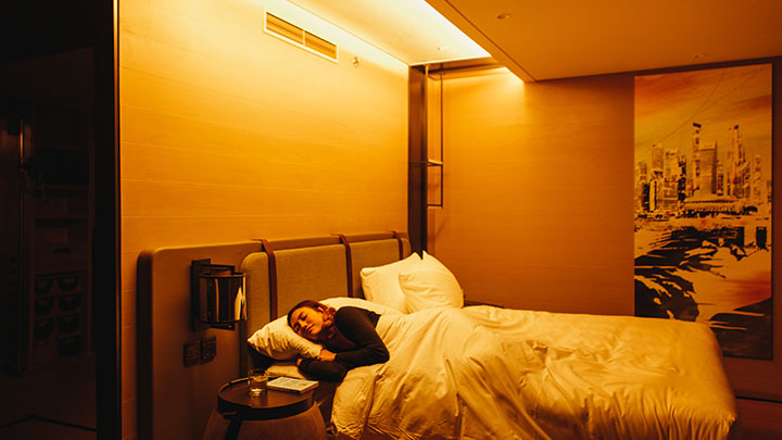 Femme se relaxant dans un lit d'hôtel