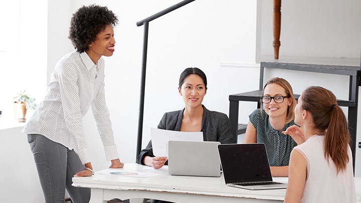 Happy colleagues collborating in open office space