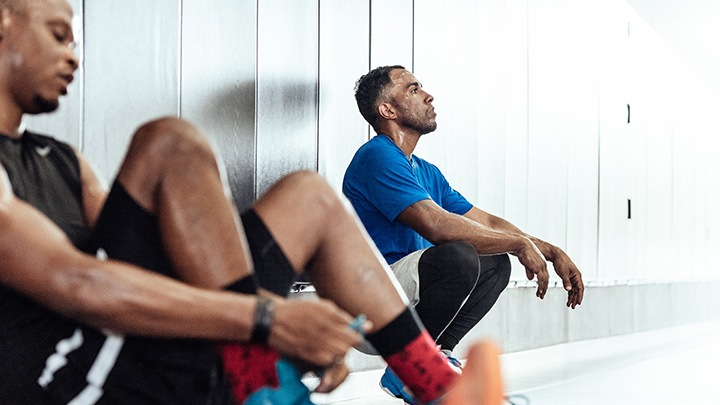  Male atheletes taking a break on locker room floor