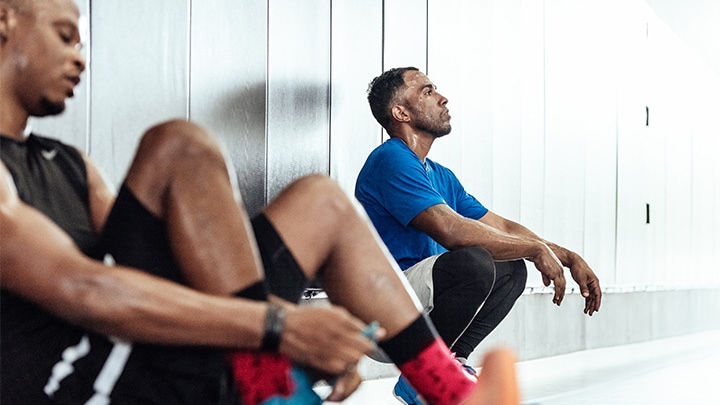 Basketballspieler machen eine Pause auf dem Boden der Umkleidekabine