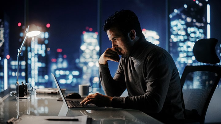 Homme au bureau avec vue sur la ville sur ordinateur portable
