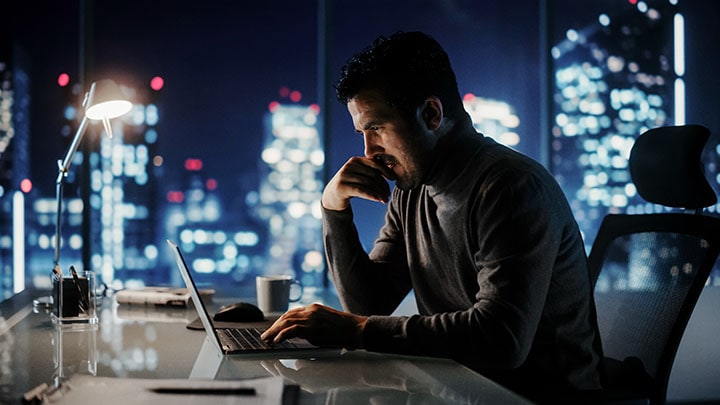 Mann im Büro mit Stadtansicht auf dem Laptop