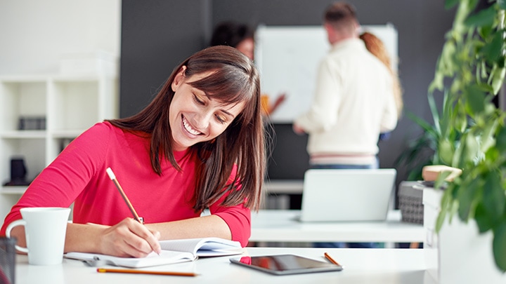 Femme écrivant des notes sur le bureau