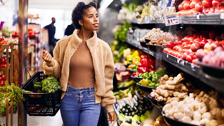 Vrouw die in een gangpad van een supermarkt loopt