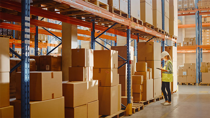 Warehouse employee stood near cardboard boxes