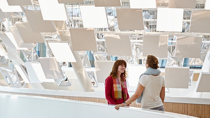 Women talking in modern hallway