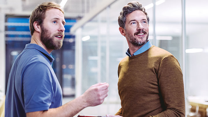 Two male colleagues discussing in office
