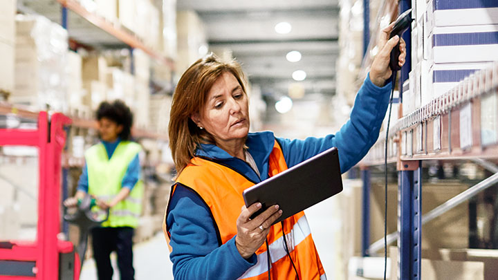 Trabajadores de almacén escanean un producto en el iPad