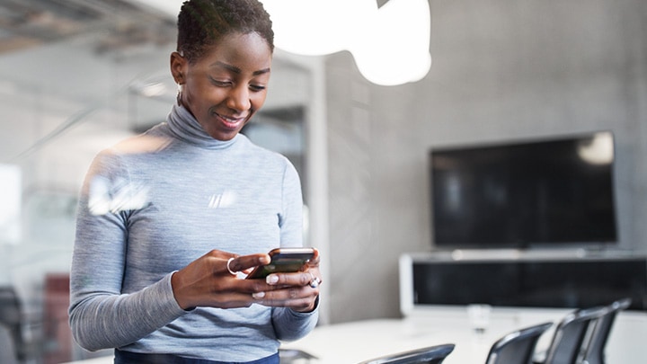 Zakenvrou die een smartphone gebruikt in een kantoor