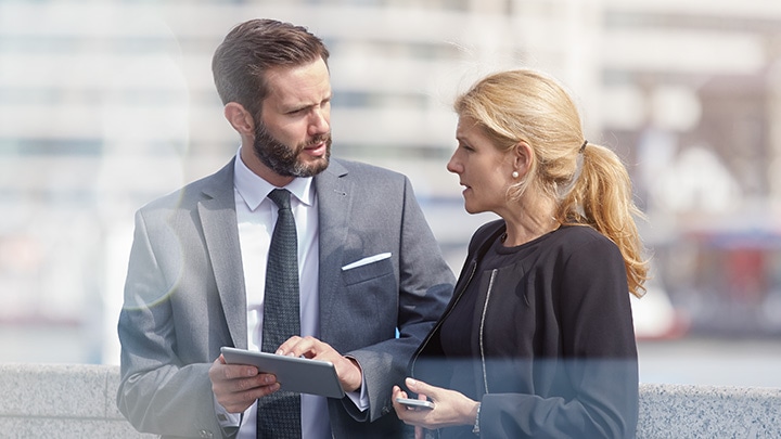 Collega's die plannen op een tablet bespreken in de stad