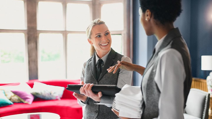 Two hotel service staff talking to each other in a lounge area