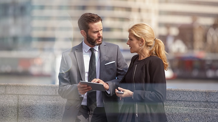 Man and woman discussing work on a tablet