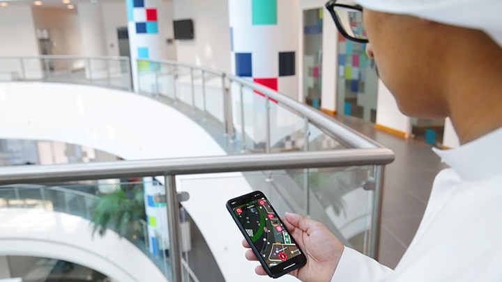 Un homme contrôlant l'éclairage d'un bâtiment à l'aide de son smartphone