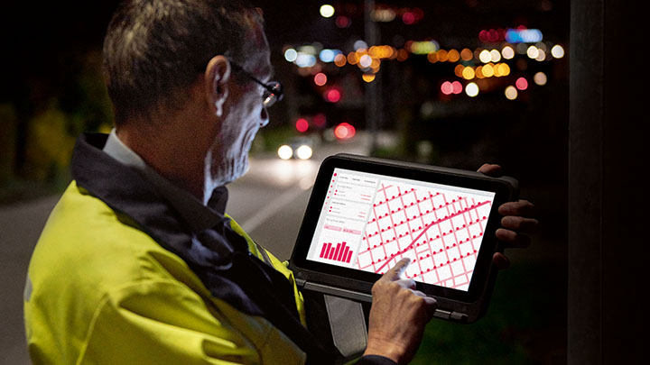 An engineer at the roadside diagnosing issues on a tablet