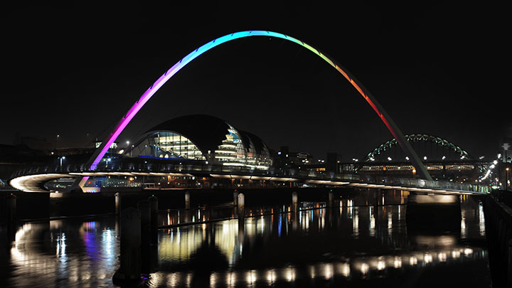 Gateshead Millennium Bridge bei Nacht mit Regenbogenbeleuchtung 