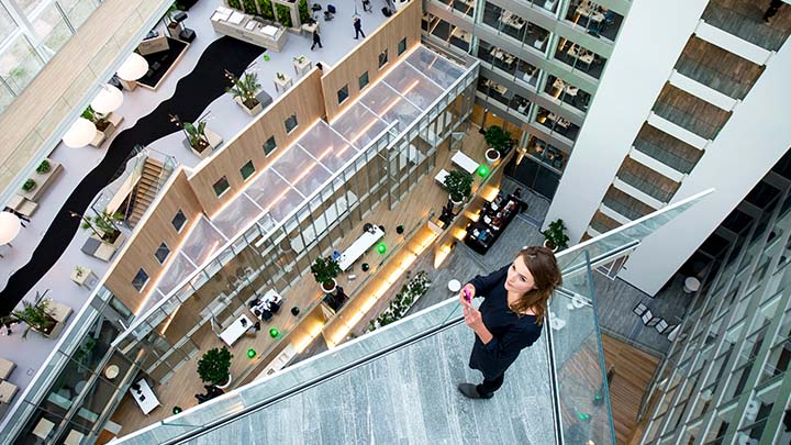 Frau in der Lobby eines mehrstöckigen Bürogebäudes