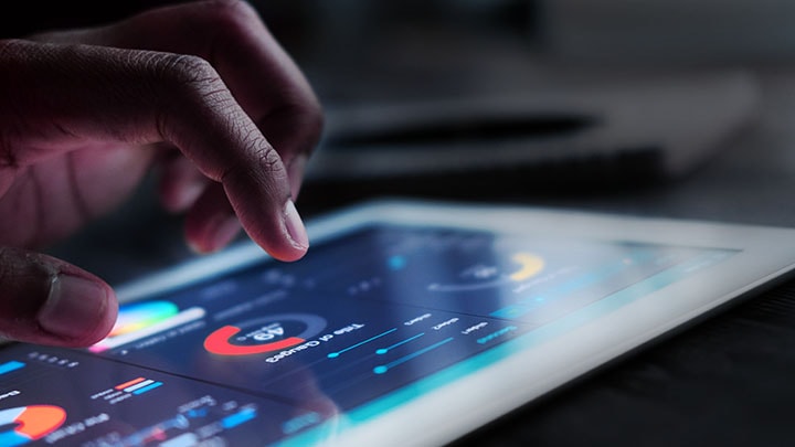 Close-up of someone using a tablet to control office lighting