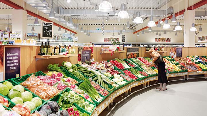 Een gangpad met groente en fruit in een supermarkt