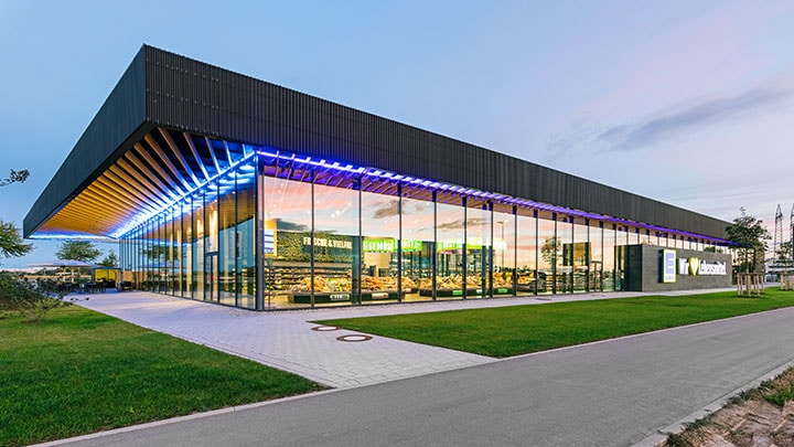 Een ultramoderne supermarkt met glazen wanden en kleurrijke verlichting