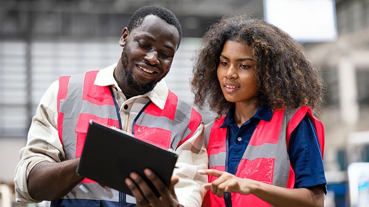 Ingénieurs de production masculin et féminin discutant de la prévision des données de production sur l'application mobile