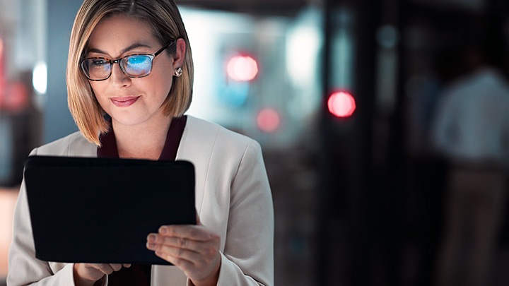 Femme d'affaires utilisant une tablette numérique pendant une fin de soirée au travail