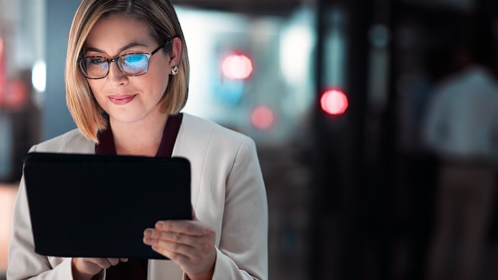 Zakenvrouw die een digitale tablet gebruikt tijdens een avond overwerken